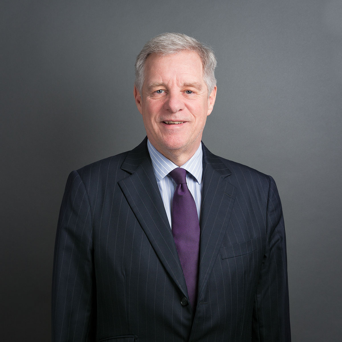 Man in suit with grey background.